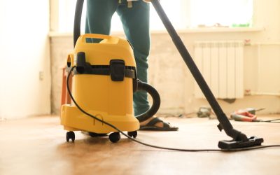 A man is cleaning the room during repairs using a construction vacuum cleaner A man is cleaning the room during repairs using a construction vacuum cleaner